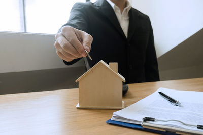 Midsection of man holding book on table