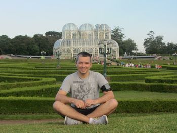 Portrait of smiling man sitting on field against sky