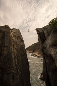 Scenic view of sea by cliff against sky