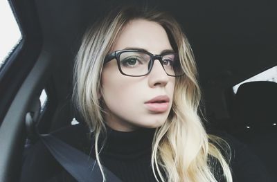Close-up portrait of beautiful young woman in car