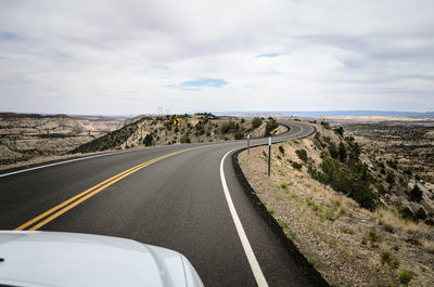 Road passing through landscape against sky