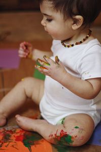 Close-up of messy baby boy playing with paint at home