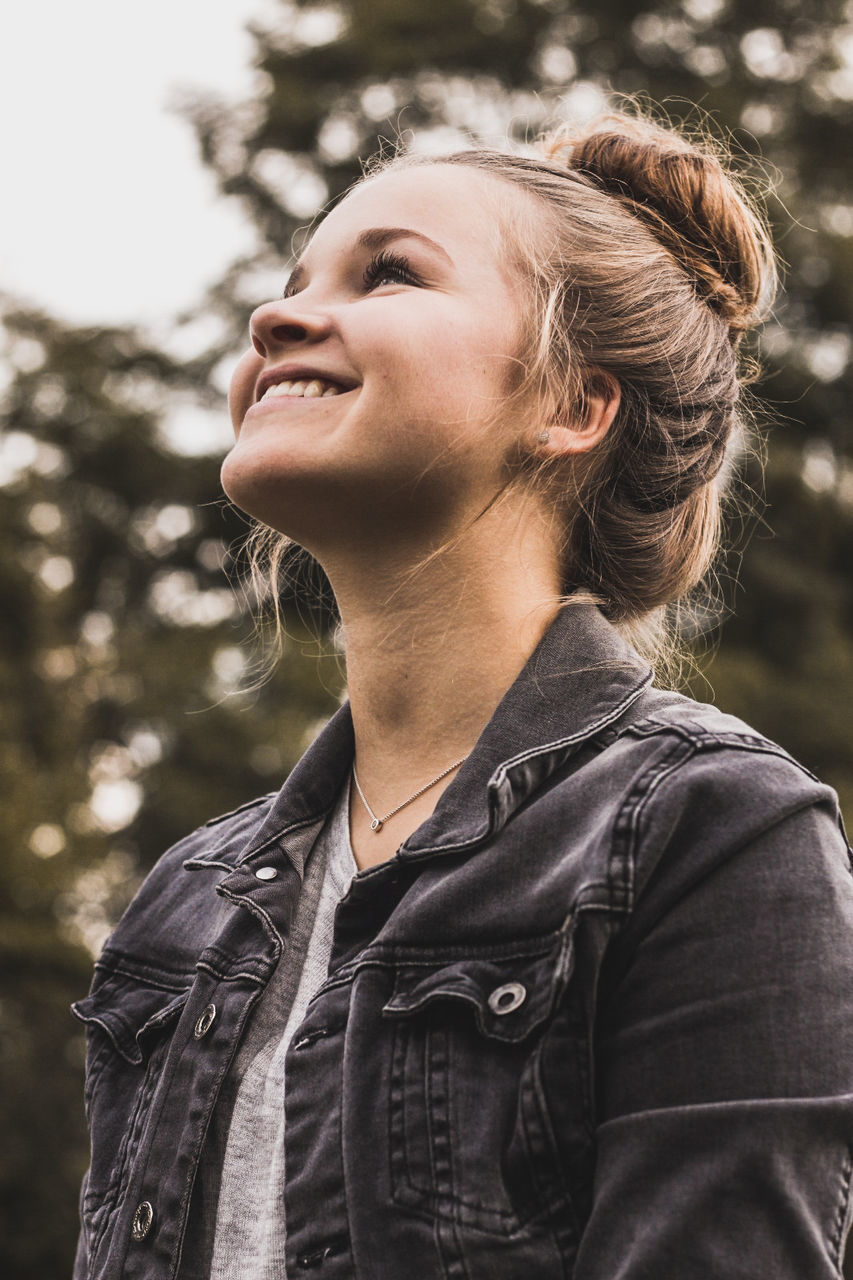 CLOSE-UP OF SMILING YOUNG WOMAN