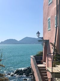 Buildings by sea against clear blue sky, tellaro