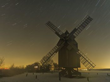 Traditional windmill against sky at night