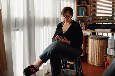 Young woman using mobile phone at home