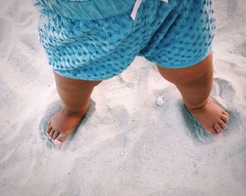 Low section of woman standing on beach