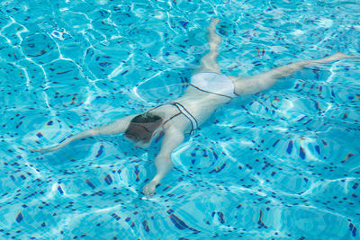 Low section of person swimming in pool