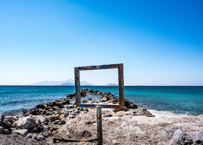 Lifeguard hut on beach against clear blue sky
