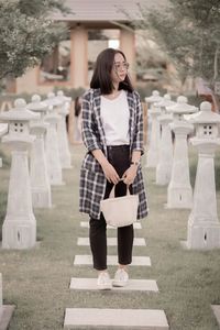 Rear view of young woman standing on footpath