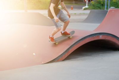Low section of boy skateboarding on skateboard