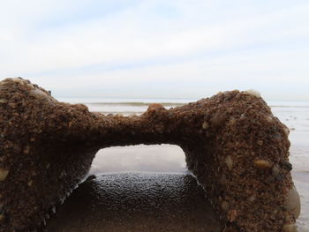 Close-up of rocks on beach against sky