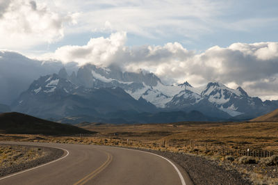 Empty road against mountains during winter