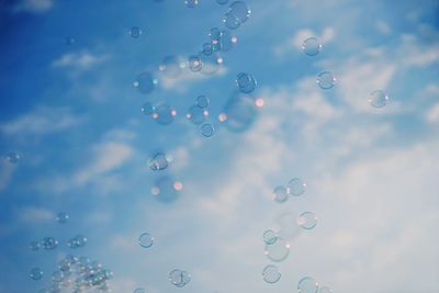 Close-up of bubbles against rainbow in sky