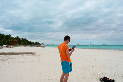 Man holding purse at beach