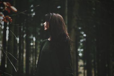 Woman standing against trees