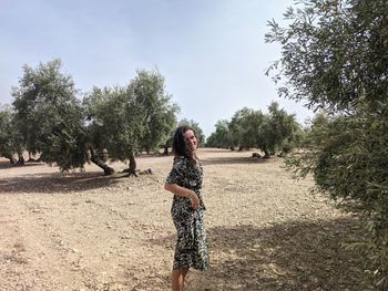 Full length of woman standing by tree against sky