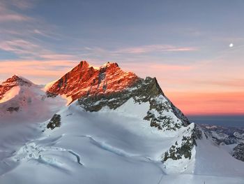 Scenic view of snow covered mountain against dramatic sky