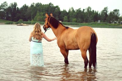 Woman with horse in river