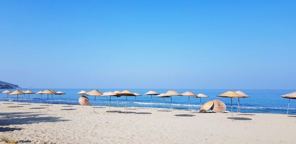 Scenic view of beach against clear blue sky