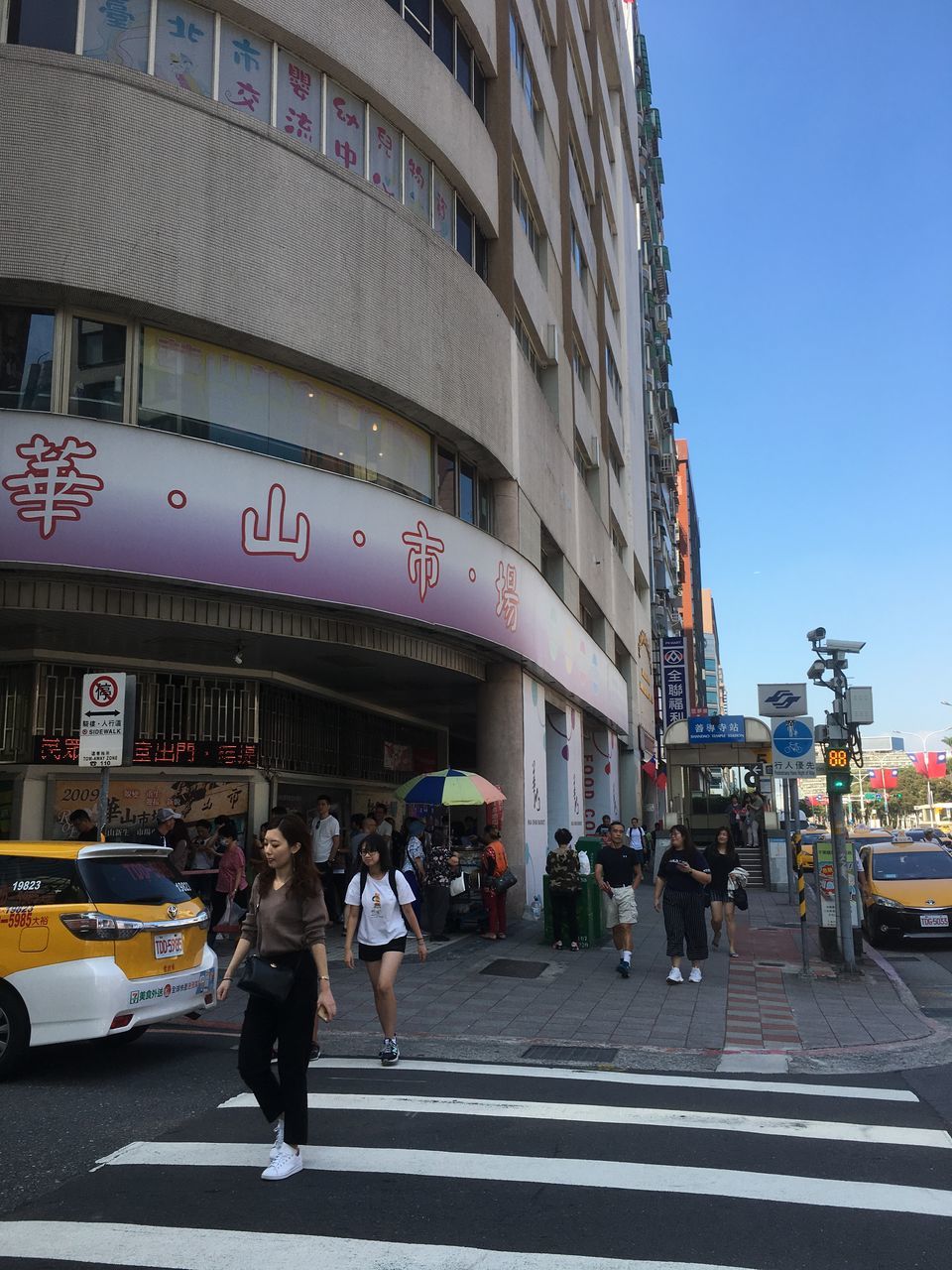 city, architecture, building exterior, built structure, street, real people, group of people, transportation, city life, road, crowd, walking, women, large group of people, road marking, men, adult, sign, city street, outdoors