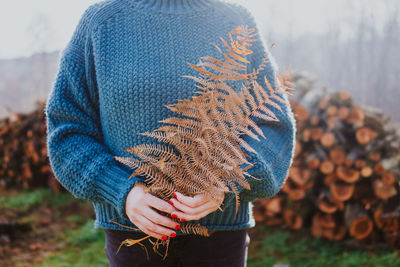 Midsection of woman holding ferns during autumn