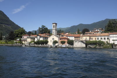 River by buildings against clear blue sky