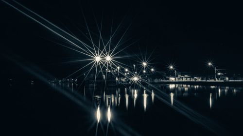 Illuminated street light with reflection in water at night