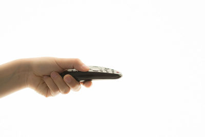 Close-up of hand holding paper over white background