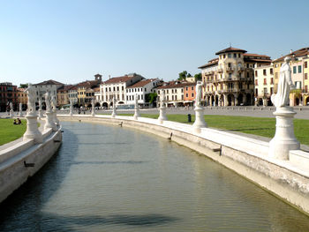 River amidst buildings in city against clear sky