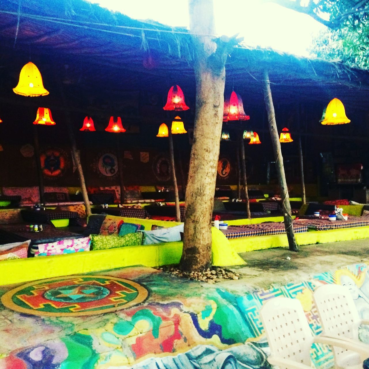 MULTI COLORED UMBRELLA BY SWIMMING POOL AT NIGHT