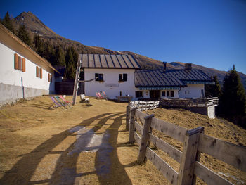 Houses and benches against clear blue sky