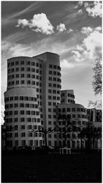 Buildings in city against cloudy sky