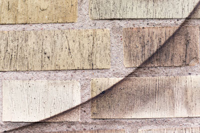 Black spray paint curve on yellow brick wall.