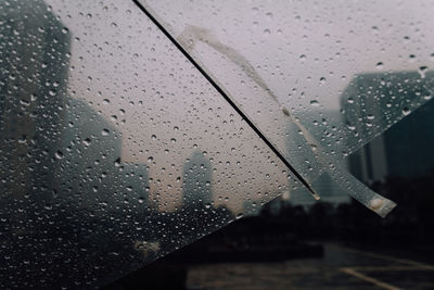 Close-up of raindrops on umbrella during monsoon