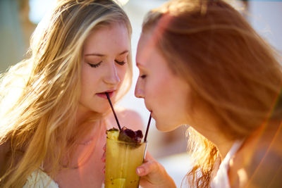 Close-up of female friends having drink outdoors