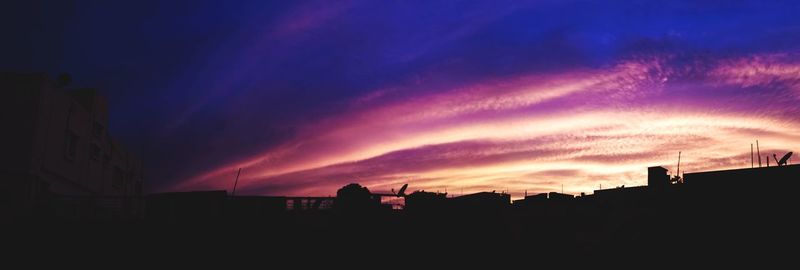 Silhouette city against sky at sunset