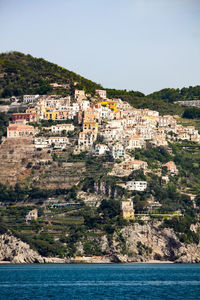 Aerial view of townscape by sea against clear sky