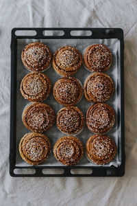 High angle view of baked cinnamon buns on baking tray