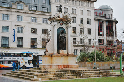 Statue by building in city