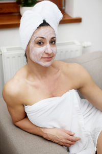 Portrait of woman applied cream on face at home