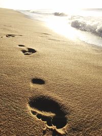 Close-up of footprints on sand at beach