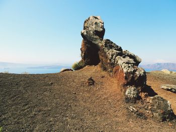 Rock formations on landscape against clear blue sky