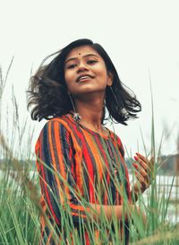 Smiling young woman looking away while standing outdoors