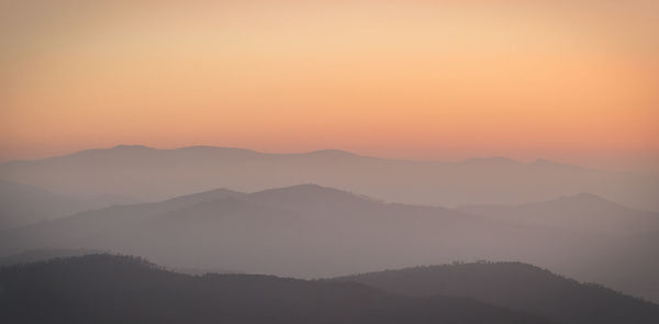 Scenic view of silhouette mountains against sky during sunset