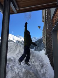 Full length of man on snowcapped mountain against sky