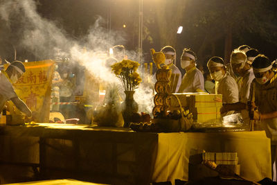 People wearing mask at illuminated street in city at night