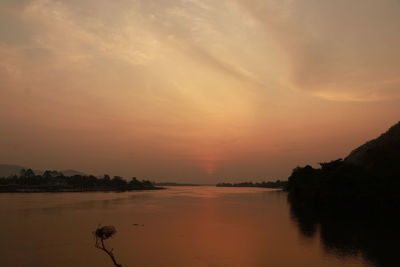 Scenic view of lake against orange sky