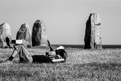 Panoramic view of man resting on field against clear sky