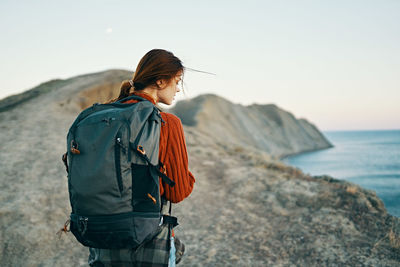 Man looking at sea shore against sky